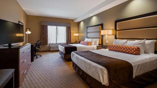 a hotel room with two beds and a flat screen tv at Best Western Plus College Park Hotel in College Park