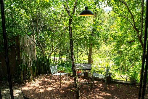 a patio with two chairs and a table and a lamp at Yolitia Wellness in Malinalco