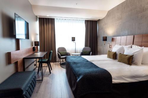 een hotelkamer met een bed en een bureau bij Scandic Simonkenttä in Helsinki