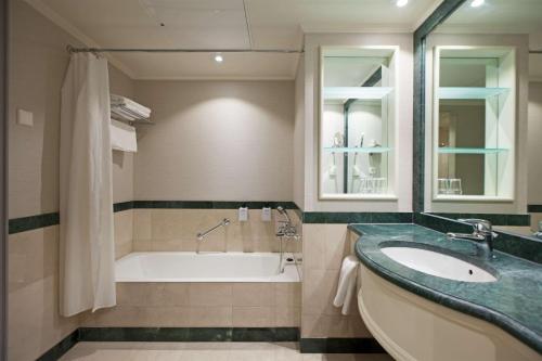 een badkamer met een bad en een wastafel bij Scandic Park Helsinki in Helsinki