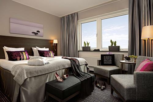 um quarto de hotel com duas camas e uma cadeira em Scandic No. 25 em Gotemburgo