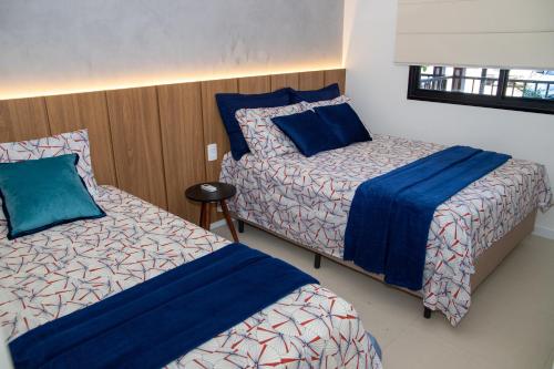 ein Schlafzimmer mit zwei Betten und einem Fenster in der Unterkunft Flat em Guarajuba in Guarajuba