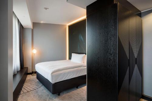 a bedroom with a bed and a black wall at Crowne Plaza Helsinki - Hesperia by IHG in Helsinki