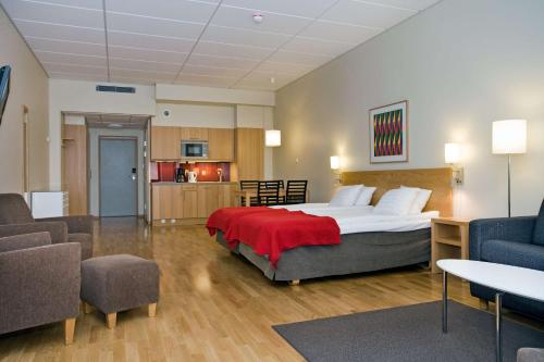 una camera da letto con un grande letto con una coperta rossa di Scandic Malmö City a Malmö