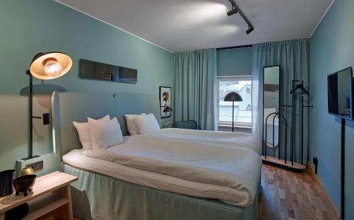 sypialnia z dużym łóżkiem w niebieskim pokoju w obiekcie Scandic Klara w Sztokholmie