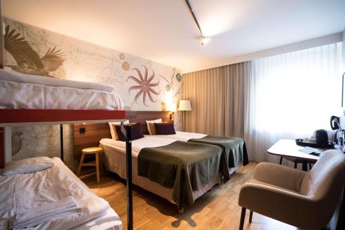 ウプランズ・ヴェスビーにあるScandic Upplands Väsbyのベッド2台とデスクが備わるホテルルームです。