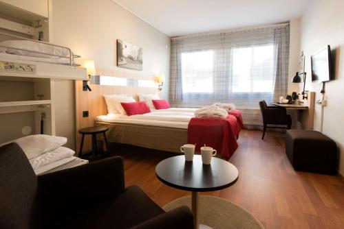 een slaapkamer met een bed, een bank en een tafel bij Scandic Sundsvall City in Sundsvall