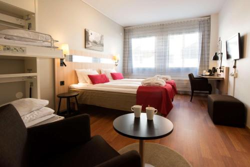 a bedroom with a bed and a couch and a table at Scandic Sundsvall City in Sundsvall