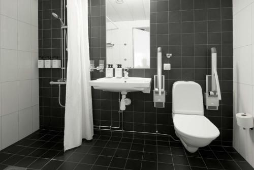 a bathroom with a toilet, sink, and bathtub at Scandic Sundsvall City in Sundsvall
