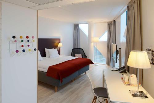 a hotel room with a bed and a desk at Scandic Victoria Tower in Stockholm
