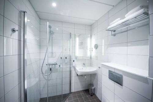 a bathroom with a shower, sink, and toilet at Scandic Bodø in Bodø