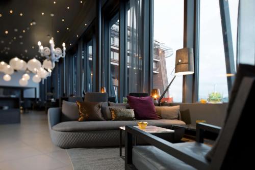 a living room with couches in a building with windows at Scandic Ishavshotel in Tromsø