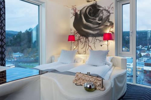 a bedroom with two beds and a large window at Scandic Rock City in Namsos