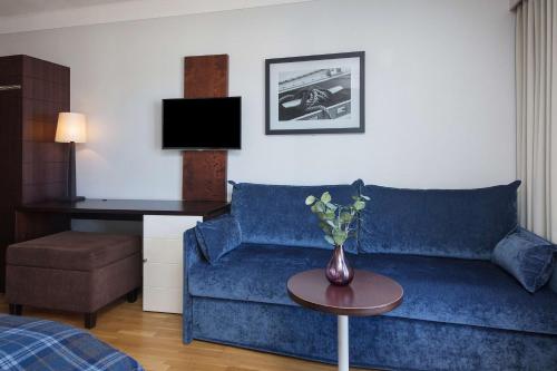 a living room with a blue couch and a table at Havna Tjøme Hotel in Tjøme