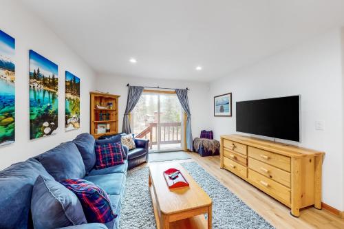 a living room with a blue couch and a flat screen tv at Tahoe's Stunner in Tahoe Vista