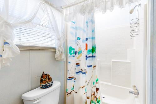 a bathroom with a shower curtain and a toilet at Assateague Point - Bay Breeze in Berlin