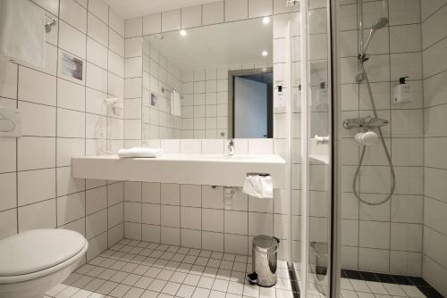 a bathroom with a shower and a sink and a toilet at Scandic Karlstad City in Karlstad