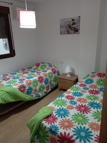 een slaapkamer met 2 aparte bedden en een nachtkastje bij Apartamento en Monachil pueblo in Monachil