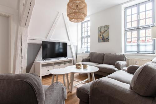 a living room with a couch and a tv at Ferienwohnungen BUNTER HOF Quedlinburg in Quedlinburg