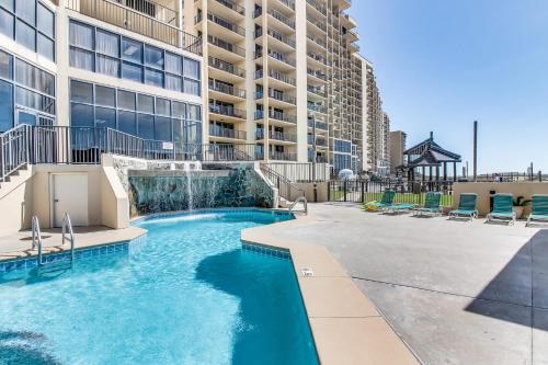a swimming pool with a waterfall in a building at Phoenix Vacation Rentals in Orange Beach