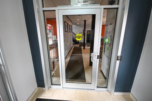a glass door with a mirror in a hallway at Le Voyageur Inn in Mattawa