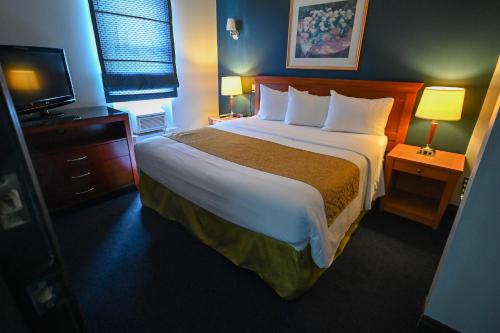 a hotel room with a large bed and a television at Le Voyageur Inn in Mattawa