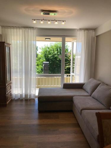 uma sala de estar com um sofá e uma grande janela em Exclusivo Departamento Céntrico em San Carlos de Bariloche