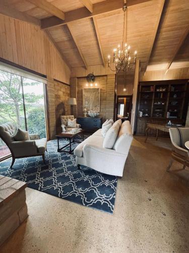 una gran sala de estar con un sofá blanco y sillas en Rivendell Farm Estate, en Tambo Upper