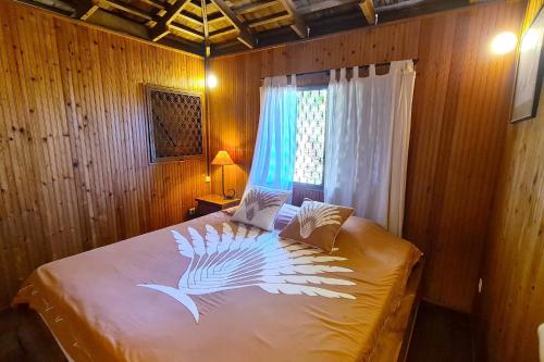 a bedroom with a bed with a bird painted on it at Villa Ylang Ylang in Haapiti