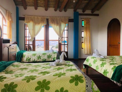 um quarto com 2 camas e uma janela em Martita's house hostal em Quilotoa