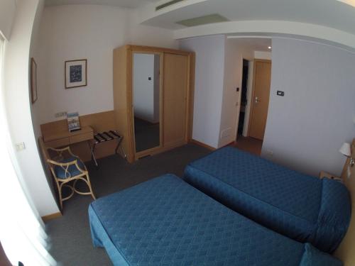 a hotel room with two beds and a desk at City Hotel in Senigallia