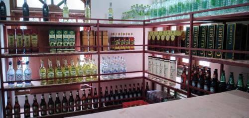 una mensola piena di bottiglie di vino di Hotel Green View Buttala a Buttala
