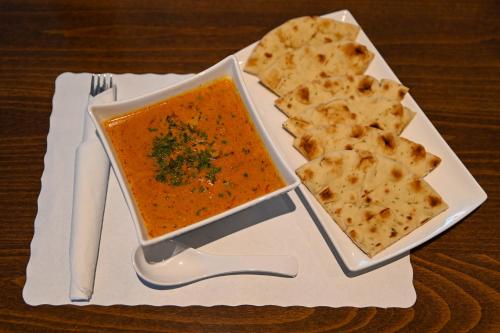 a plate with a bowl of soup and some crackers at Le Voyageur Inn in Mattawa