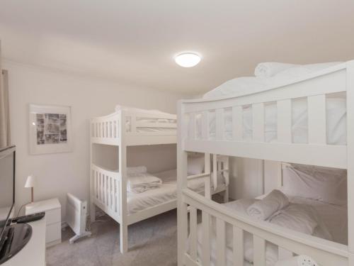 - 2 lits superposés blancs dans une chambre blanche dans l'établissement Oberlaken 2 125 Gippsland Street, à Jindabyne