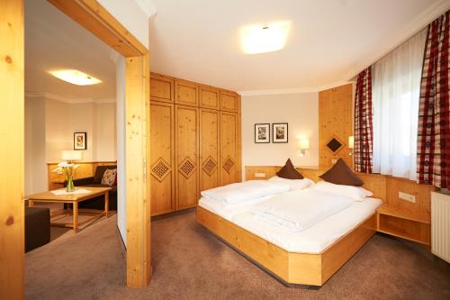 um quarto com uma cama grande num quarto em Hotel Waidmannsheil em Flachau