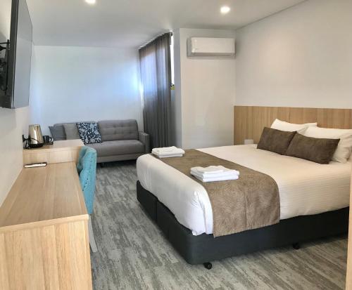 a hotel room with a bed and a couch at The Osmond Motel & Apartments in Adelaide
