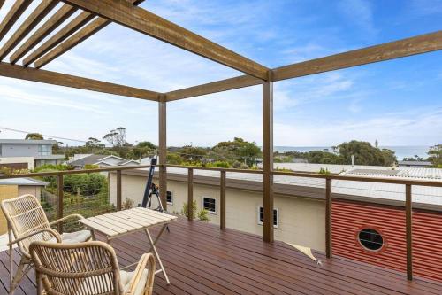 a large deck with a table and chairs on it at Sea Haven: coastal views, family retreat in McCrae