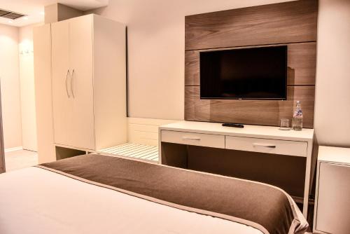 a bedroom with a bed and a flat screen tv at VH Broadway Tirana Hotel in Tirana