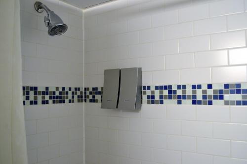 a bathroom with a shower with blue and white tiles at Beach House Dewey in Dewey Beach