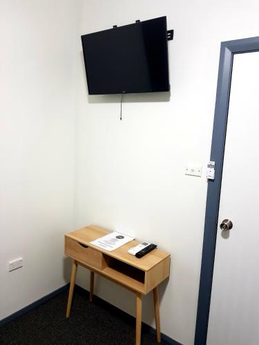 a room with a table with a television on a wall at Criterion Hotel Grenfell in Grenfell