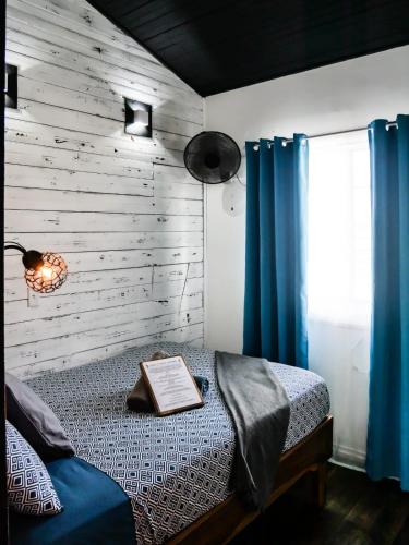 a bedroom with a bed with a book on it at Barrbra BnB Over The Sea in Bocas del Toro