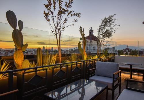 a balcony with a chair and a table on a roof at Hotel Tamara in Puebla