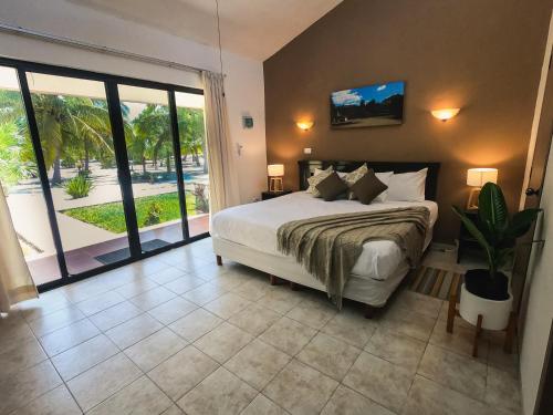 ein Schlafzimmer mit einem Bett und einem großen Fenster in der Unterkunft PRECIOSA VILLA FRENTE AL MAR in Celestún