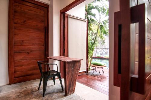a wooden table and chair in a room with a door at Sarina Hotel & Villa in Phnom Penh