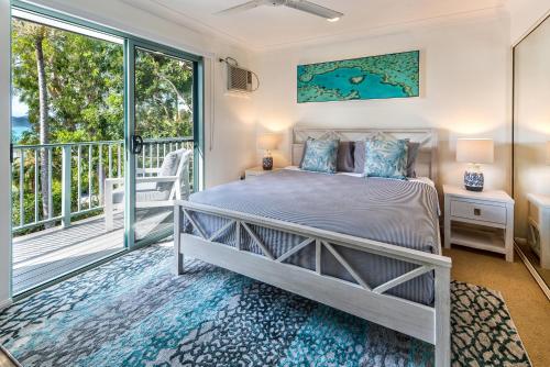 1 dormitorio con 1 cama y balcón en Sunset Waters 12 on Hamilton Island by HamoRent, en Hamilton Island