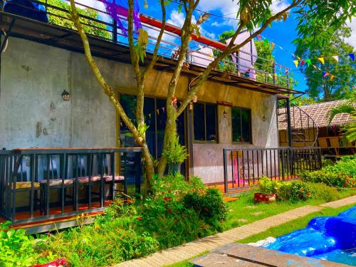 a house with a balcony and a yard at บ้านเดอะเมาเท่น By The Mountain Ozoneบ้านโอโซนขุนเขาแก่งกระจาน in Ban Song Phi Nong
