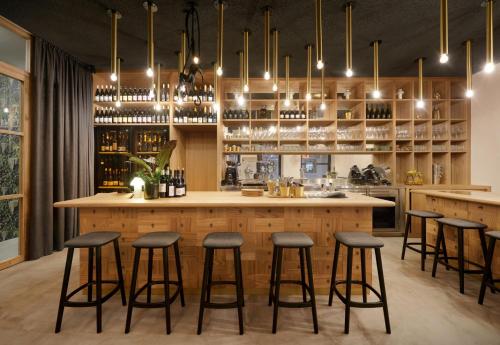 a kitchen with a bar with bar stools at Goldengel Design - Suiten im historischen Ortskern von Kaltern in Caldaro
