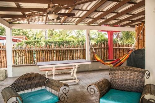 a porch with a hammock and a bench at Bed & Surf House El Palmar in Las Palmeras