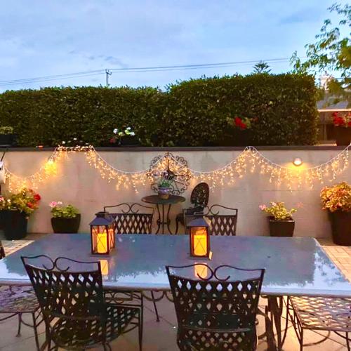 a patio with a table and chairs and lights at Kurrajong House in Launceston