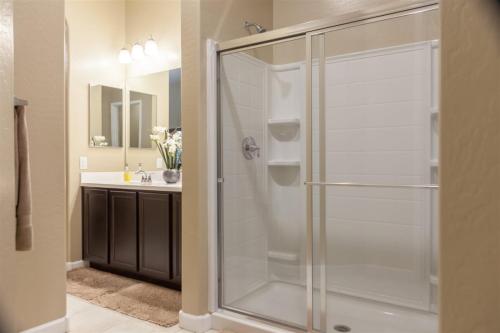 a glass shower in a bathroom with a sink at Gated townhouse with heated pool, hot tub, near US60 in Mesa